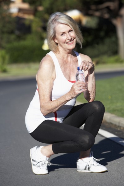 Senior Woman Resting And Drinking Water After Exercise