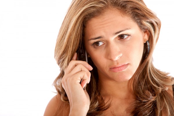 Business woman looking sad on the phone isolated over a white background