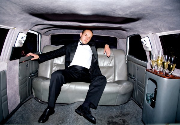 guy inside a limousine all alone with some champagne