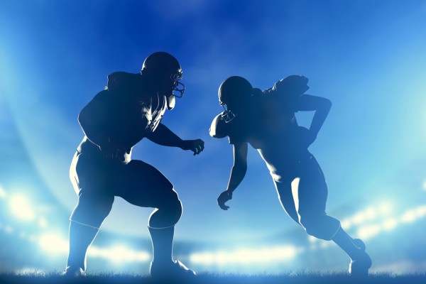 American football players in game, quarterback running. Stadium lights