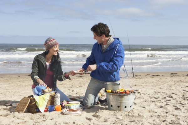 Couple Having Barbeque On Winter Beach