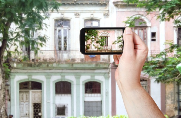 tourist taking photo of old building in Havana