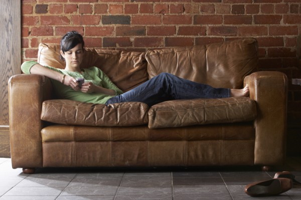 Young woman with phone on sofa