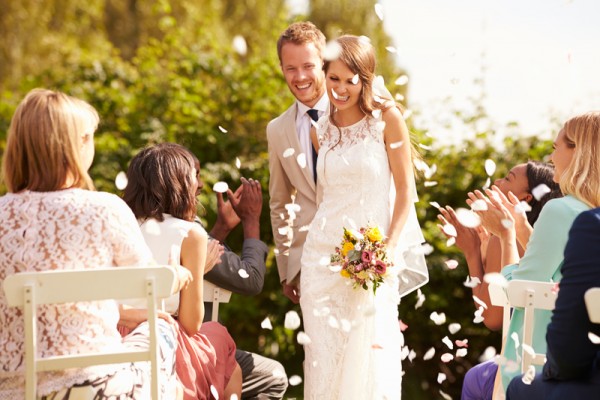 Guests Throwing Confetti Over Bride And Groom At Wedding