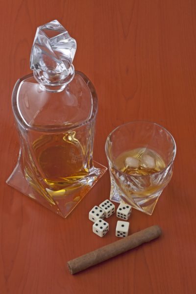 Whisky, cigar, dice and cards over wooden background