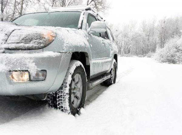 Snowy winter road behind an unrecognizable car