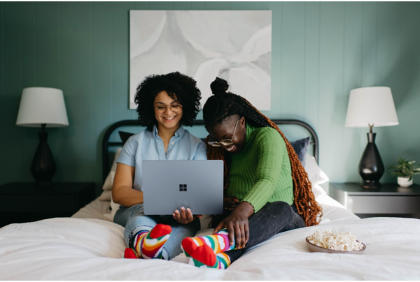 Two women smiling and using a top AI search platform, showcasing a user-friendly experience design essential for fostering effective user interaction
